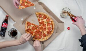 Top view of friends sharing pepperoni pizza and enjoying Coca Cola. - Photo by cottonbro studio on Pexels