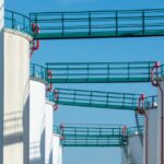 Modern industrial storage tanks with walkways against a clear blue sky. - Photo by Jan van der Wolf on Pexels