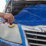 Car headlight being polished by a mechanic using an electric tool indoors. - Photo by Khunkorn Laowisit on Pexels