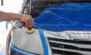 Car headlight being polished by a mechanic using an electric tool indoors. - Photo by Khunkorn Laowisit on Pexels